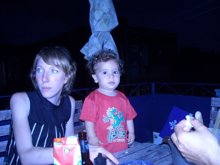 a man and his son sitting outside at night