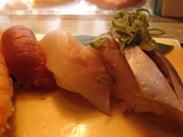 various types of sushi arranged in a single triangle on a  board