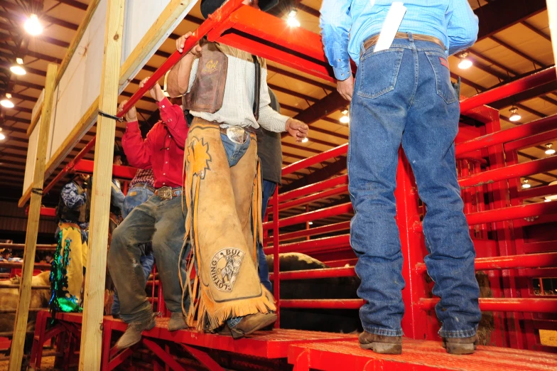 men stand on the back of a pickup truck as they prepare to load their vehicles