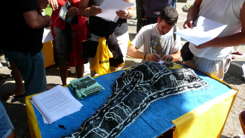 people gathered around a blue and yellow table cloth