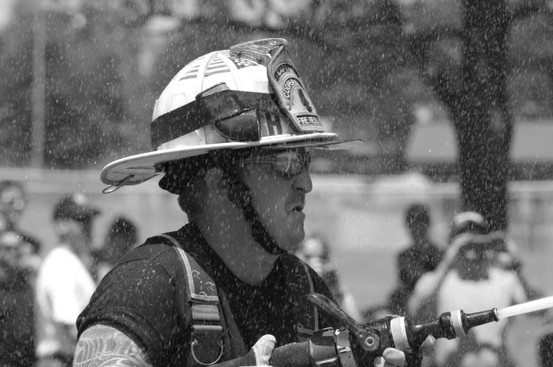 a firefighter in the rain holding a gun