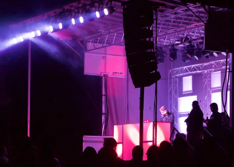 a group of people on stage with purple lighting