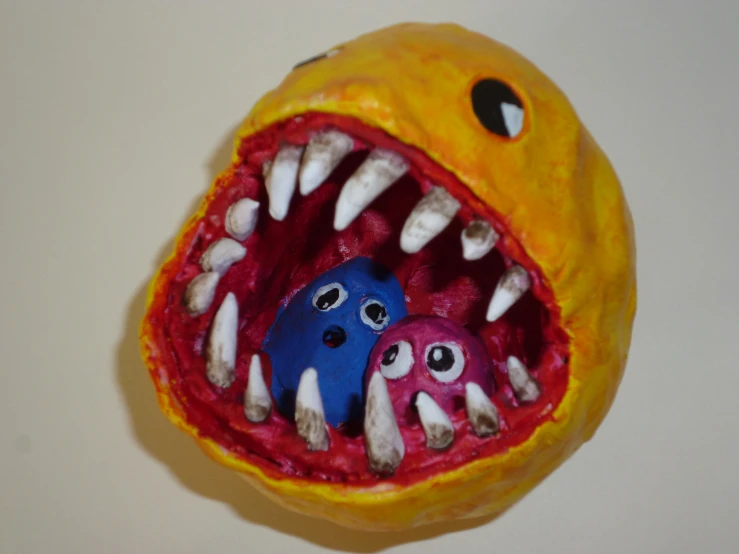 two brightly colored monster heads with teeth and large teeth