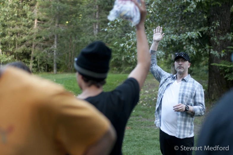 a man throws his hands up in the air in a field