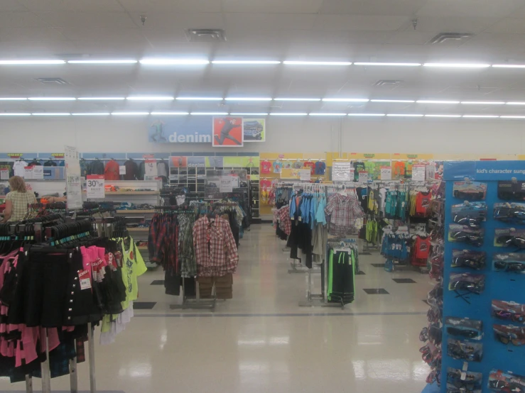 an aisle with luggage, shirts and more in store