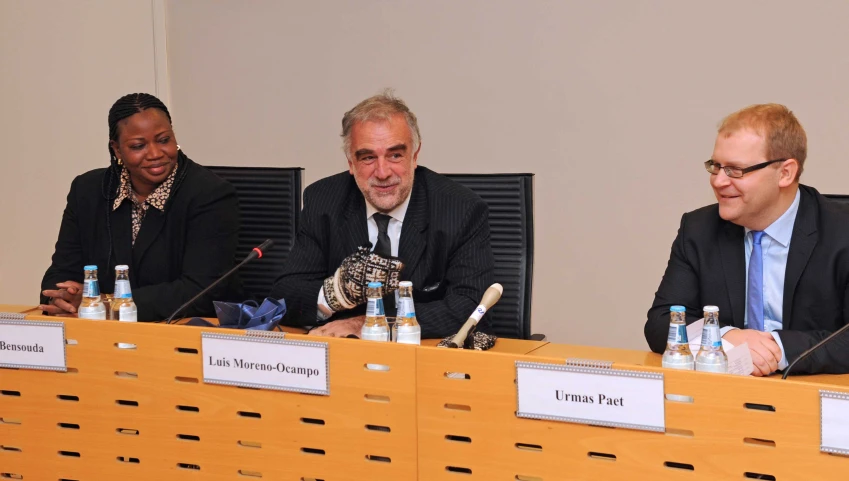 three men and a woman sit in front of a panel