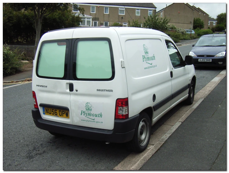 a small white van parked in front of a street