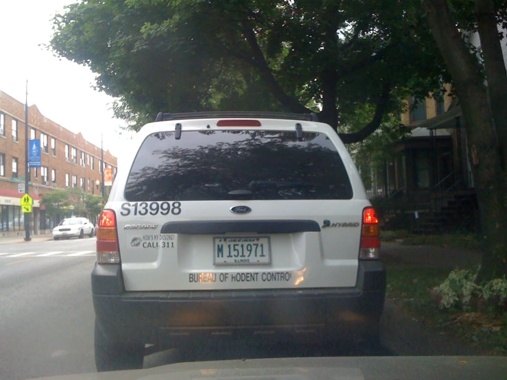 the back end of a white vehicle parked on the street