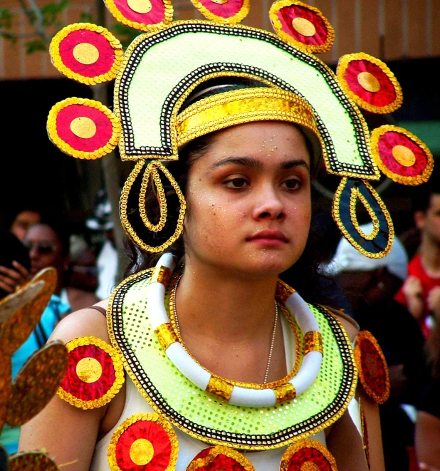 woman in a costume stands at the forefront, with people watching