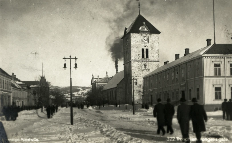 a group of people walking down a snowy street next to a building