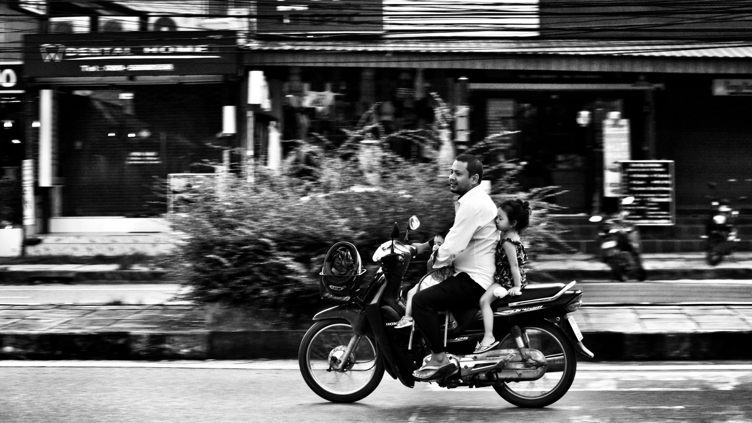 a man and woman on a motorcycle moving down the street