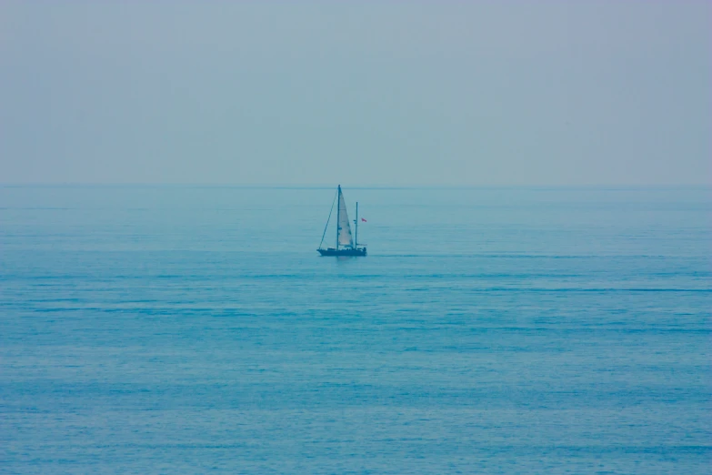 sail boat in the ocean on a hazy day