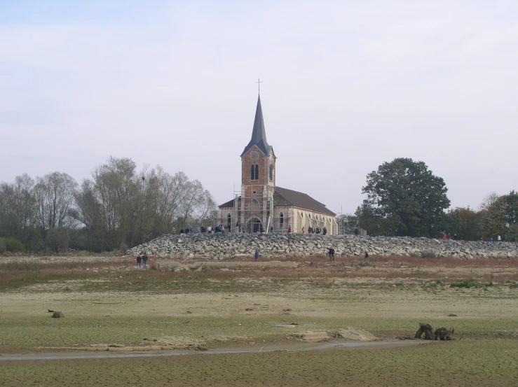 people walking across the grass outside of a church