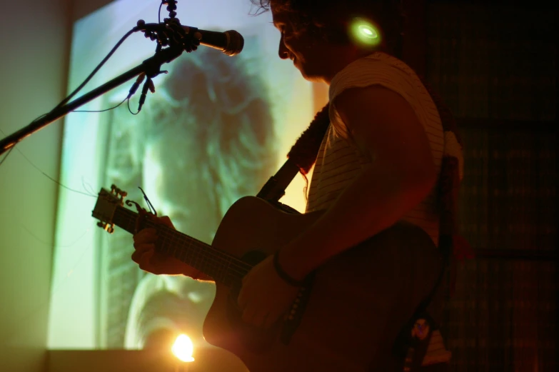 man with headphones on playing the guitar