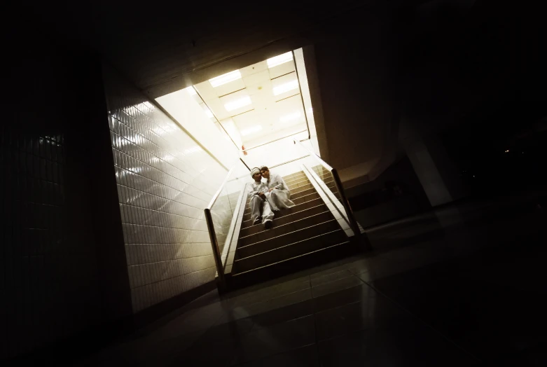 a man sitting on the steps of a stairwell in a building