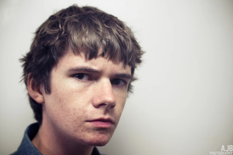 young man in the image wearing a grey polo shirt