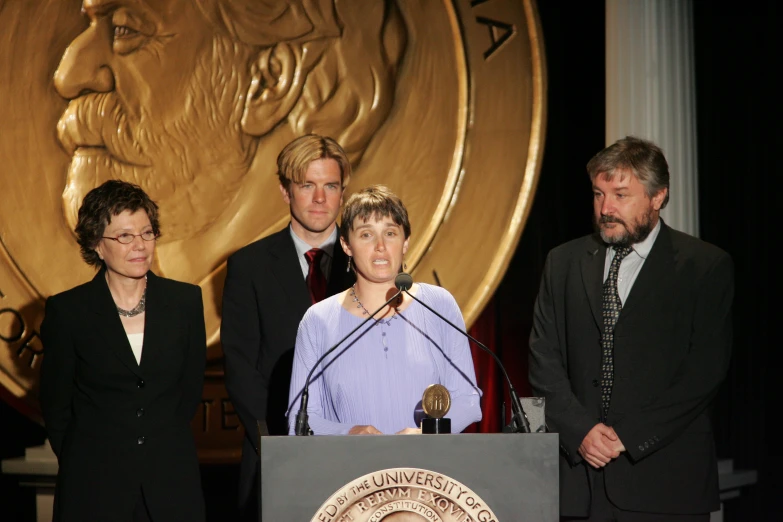 some people stand next to the speakers and an award plaque