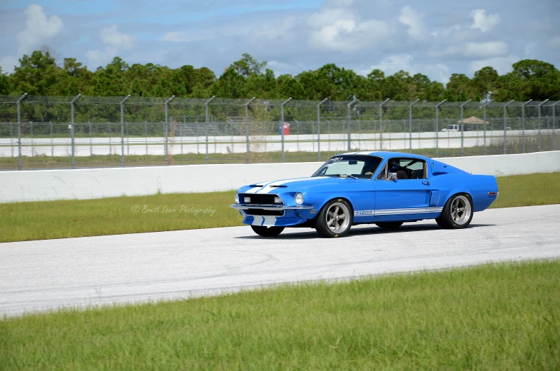 an old ford mustang driving on a track