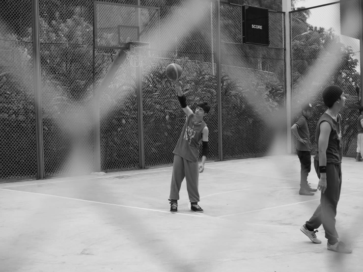 a group of boys stand in a batting cage