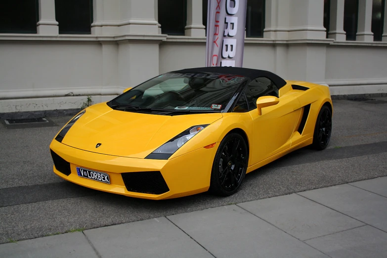 a yellow sports car parked next to a sidewalk