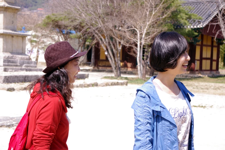 two women with hats looking at each other