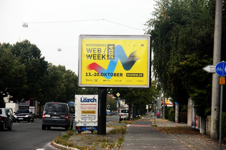 a sign for a web weekly on the side of a road