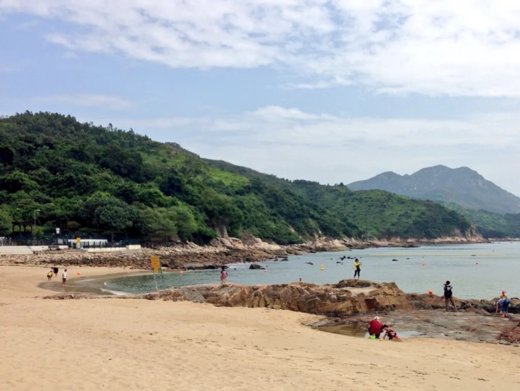 there are people on the beach looking at a boat