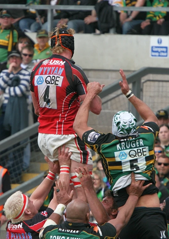 the players are on their knees reaching for a rugby ball