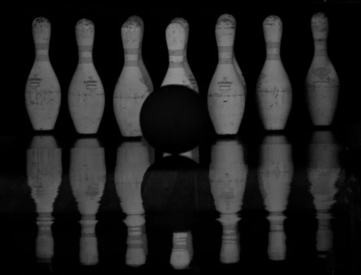 a row of bowling pins in front of some water