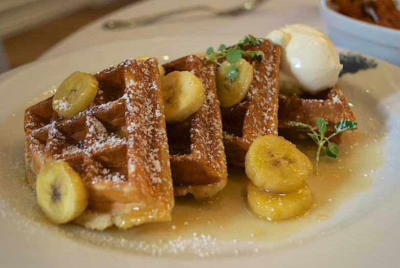 a waffle with bananas and ice cream on it