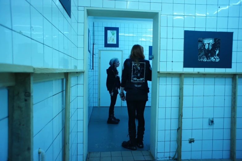 two people walking through an elevator to reach another person