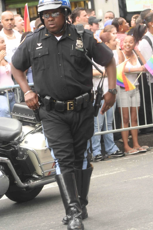 a police officer walking on a street in front of a crowd