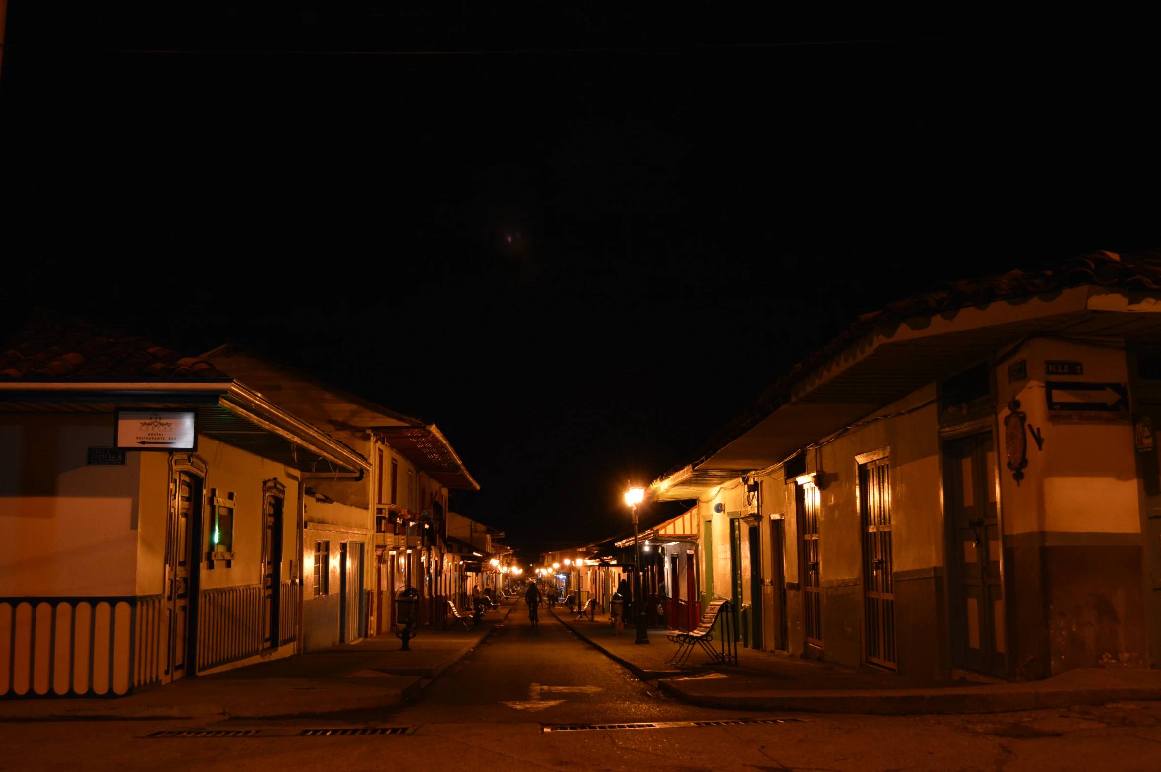 several old buildings on the side of an empty street at night