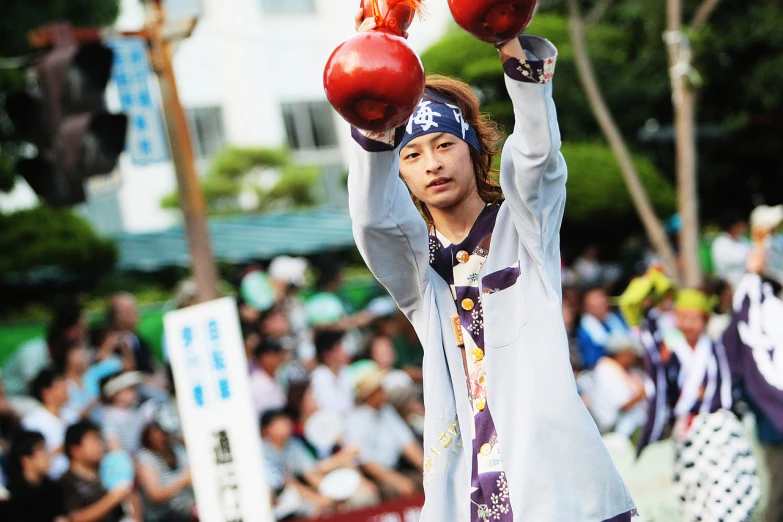 the man is balancing three apples on his shoulders