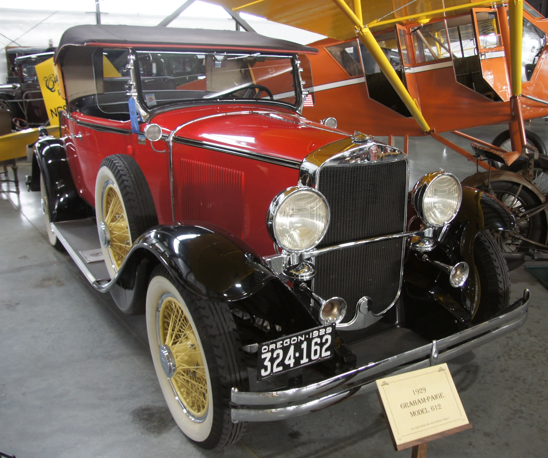 an old - fashioned car with yellow tires parked in a garage