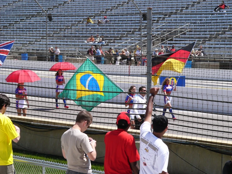 some people standing in a bleachers looking at some flags