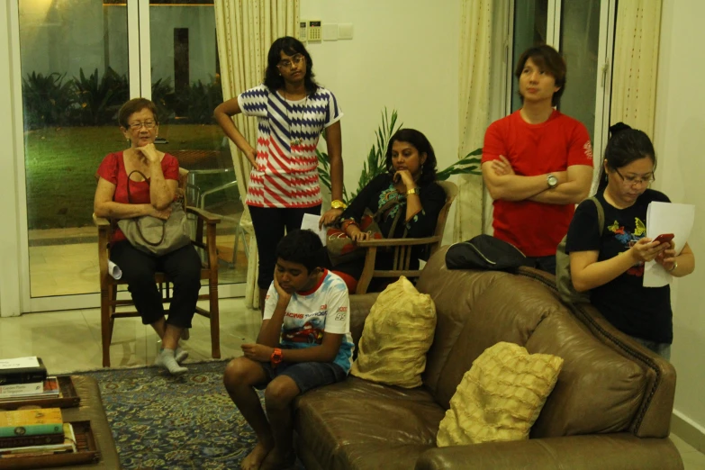 several people with red shirts sitting in a living room