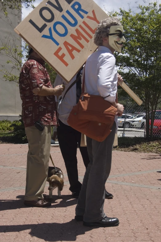 two people are standing on the street with signs that say love your family