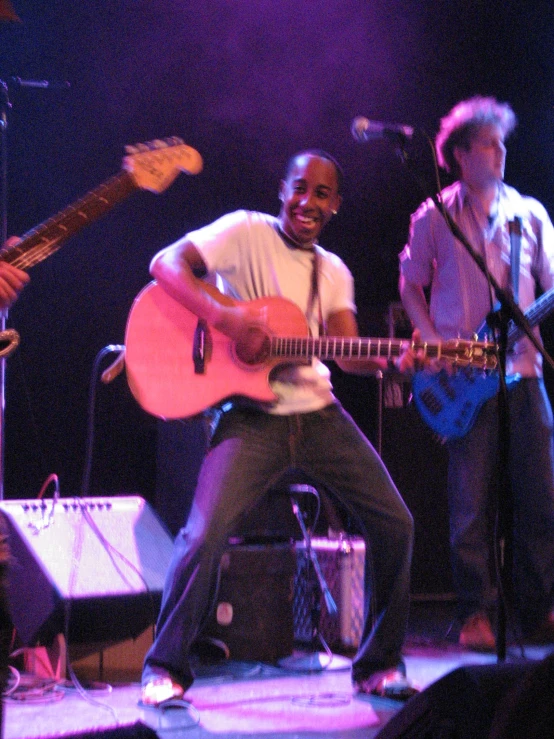 man sitting on a stool playing a guitar