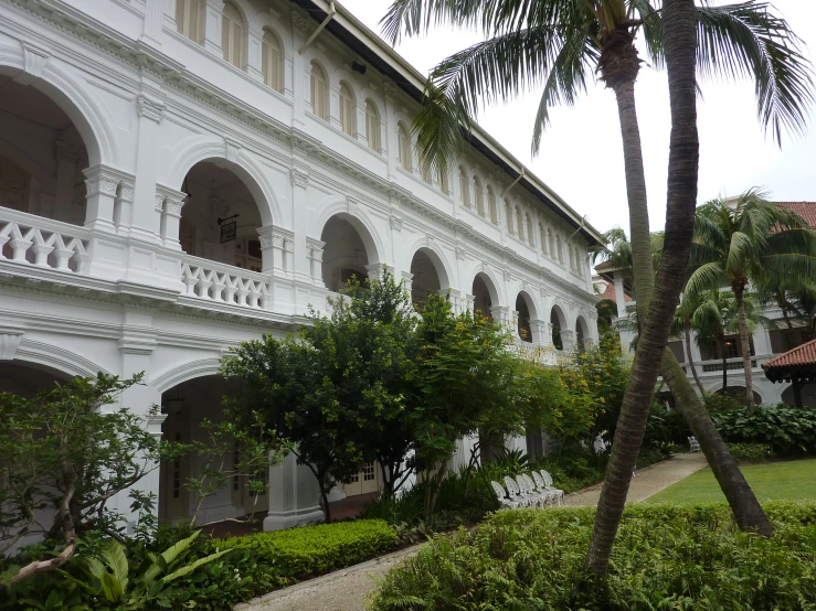 the exterior of the white building has arches and pillars on either side