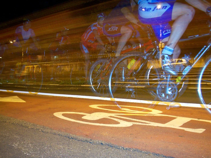 cyclists riding down the street at night in an indoor race