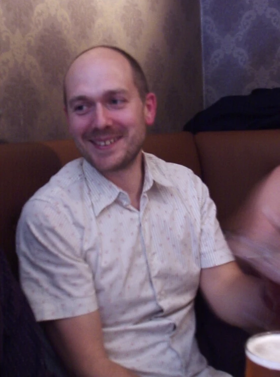 man sitting on a booth next to another person