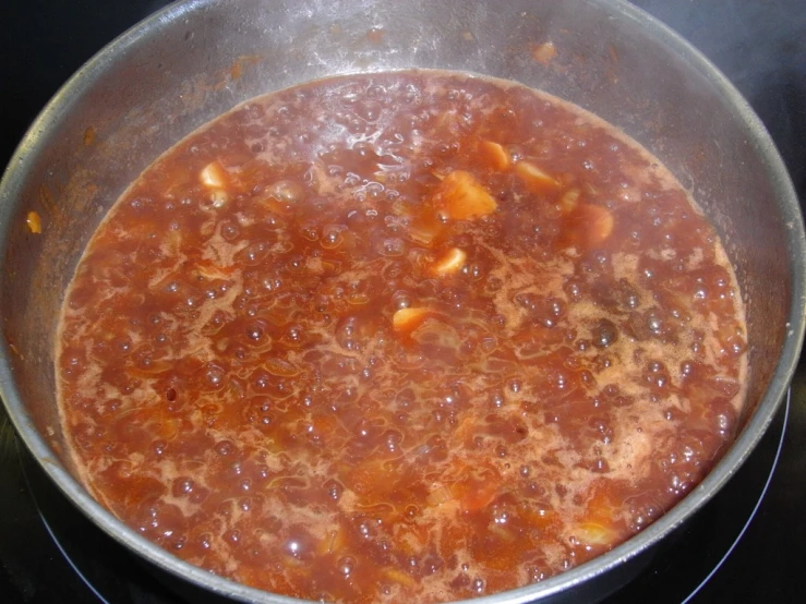 an open pot filled with stew on top of a stove