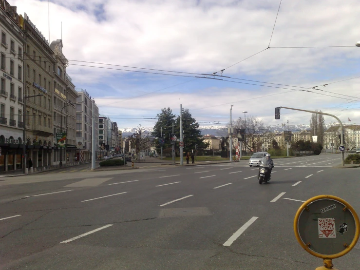 a car driving down a street past tall buildings