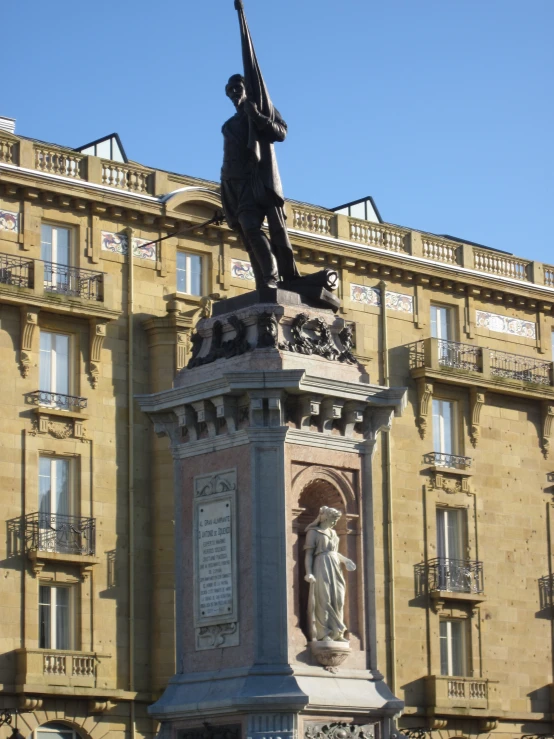 a statue stands in front of a large building