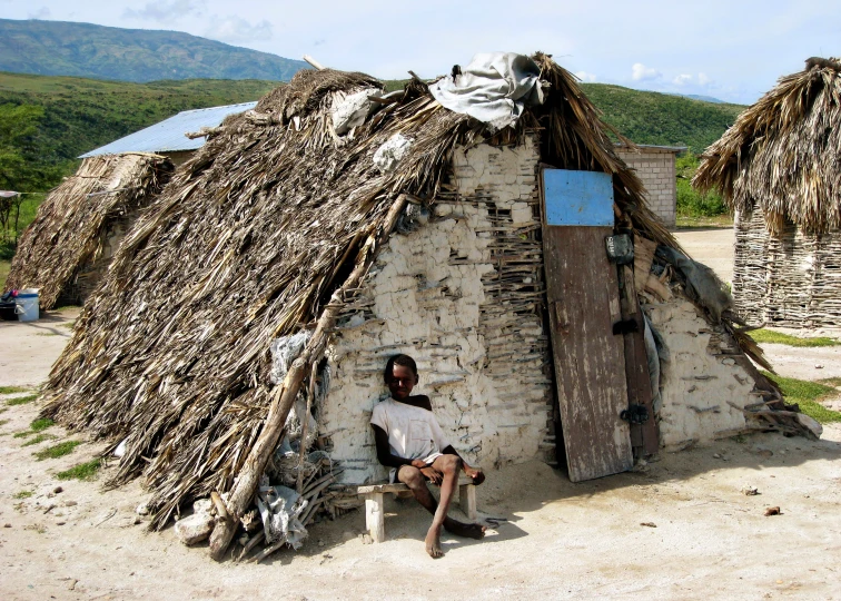 a man sits in front of an old building that has been built into it