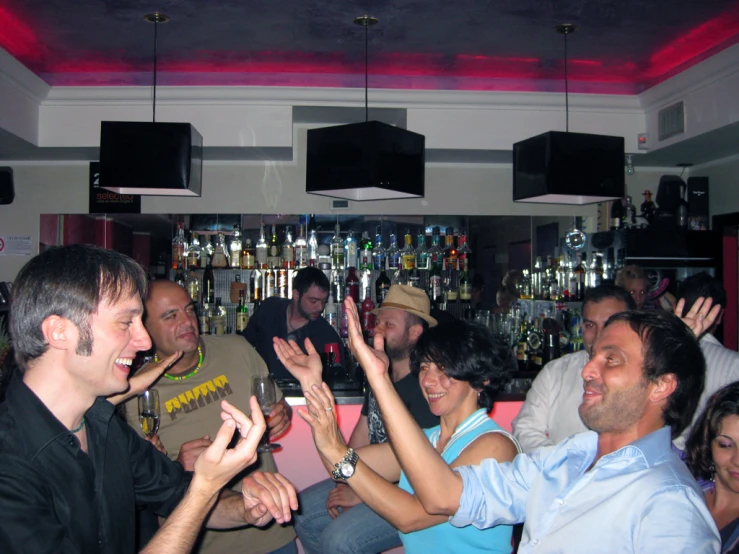 many people and one man are clapping in a bar