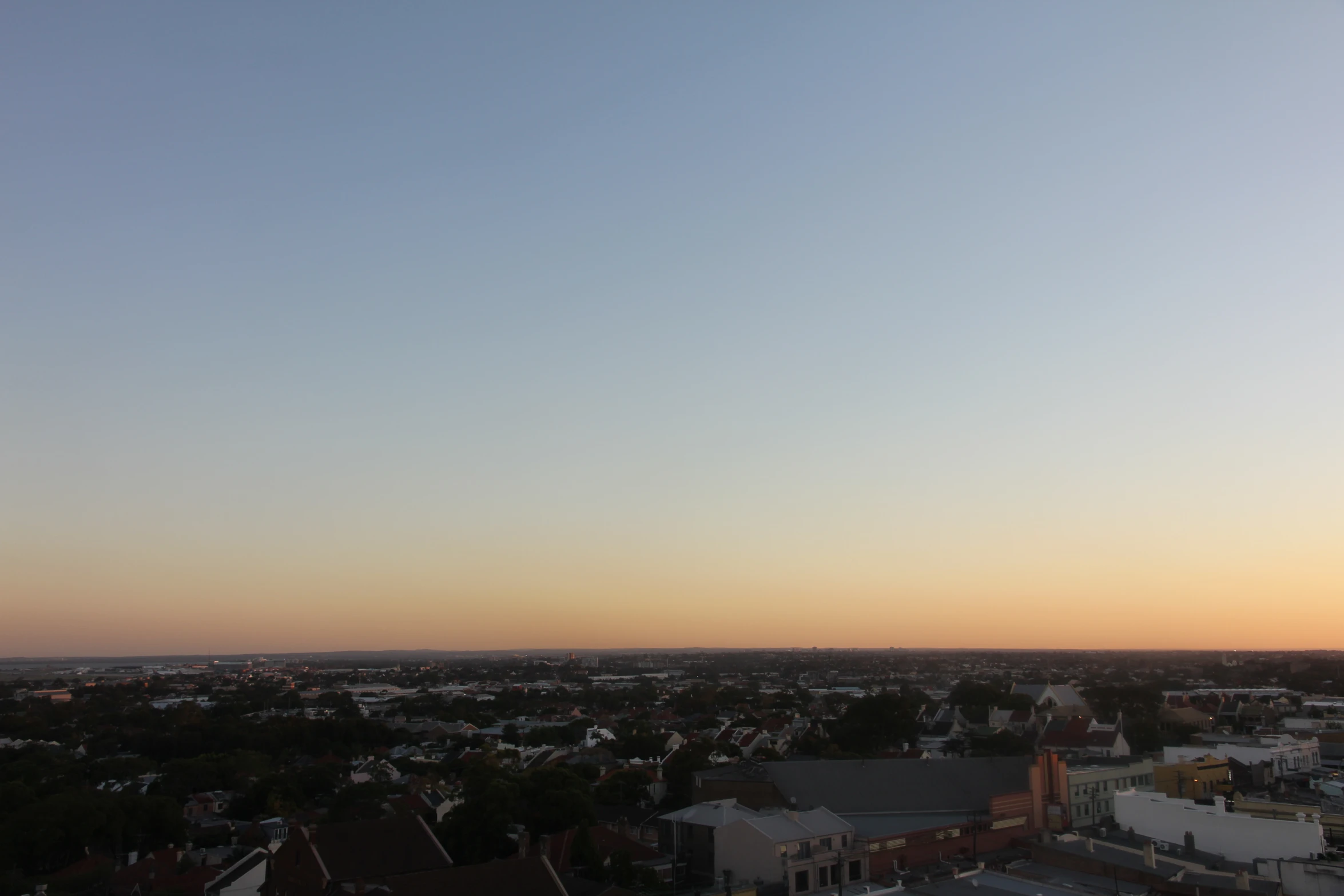 the view of some buildings and houses from a hill