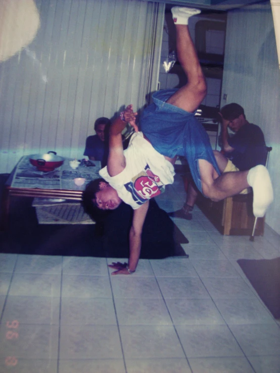 a man doing handstand with another man holding him up