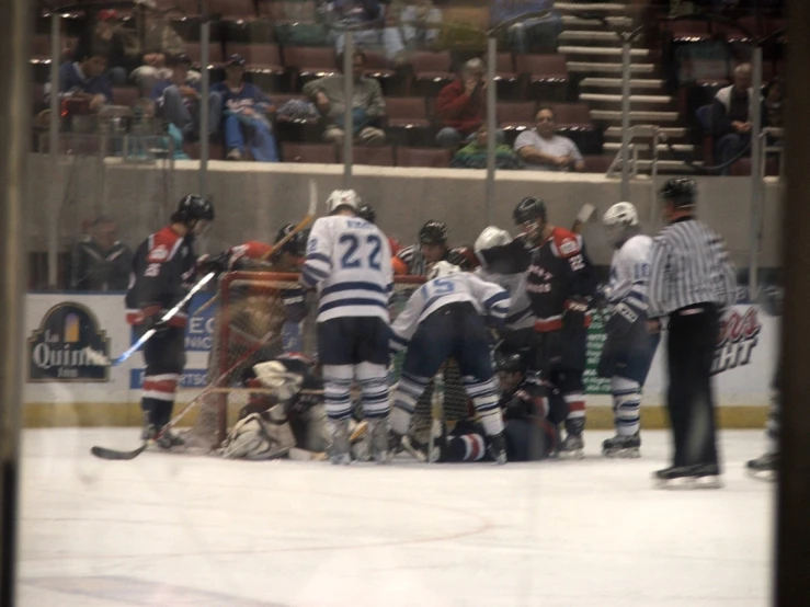 a group of people playing ice hockey near an audience